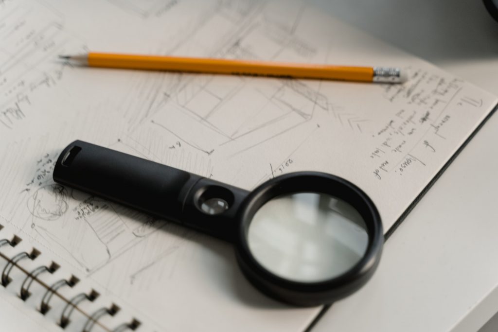 Magnifying glass next to pencil - planning